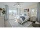 Bright bedroom featuring a large window, ceiling fan, and neutral decor with a beach-themed artwork at 4077 S Sabrina Dr # 138, Chandler, AZ 85248