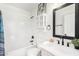 Clean bathroom featuring white tile, modern fixtures, and storage cabinet at 43795 W Sagebrush Trl, Maricopa, AZ 85138