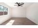 A bright bedroom featuring wood flooring, a ceiling fan and natural lighting at 43795 W Sagebrush Trl, Maricopa, AZ 85138