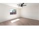 A bright bedroom with a ceiling fan and natural light from a large window at 43795 W Sagebrush Trl, Maricopa, AZ 85138