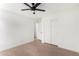 A bright bedroom features a ceiling fan and double door closet at 43795 W Sagebrush Trl, Maricopa, AZ 85138