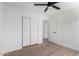 A bedroom featuring wood flooring, double closet, and ceiling fan at 43795 W Sagebrush Trl, Maricopa, AZ 85138