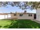 Spacious backyard with lush green grass, a covered patio, and a white exterior, perfect for outdoor living at 458 N Drew W St # West, Mesa, AZ 85201