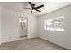 This bedroom features a ceiling fan, carpet flooring, and a window, alongside an ensuite bathroom at 458 N Drew W St # West, Mesa, AZ 85201