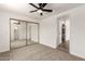 This bedroom features a ceiling fan, carpet flooring, closet with mirrored doors and doorway to ensuite bathroom at 458 N Drew W St # West, Mesa, AZ 85201