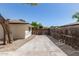 Long concrete driveway leads to a wooden gate, bordered by a wooden fence and a tree at 458 N Drew W St # West, Mesa, AZ 85201