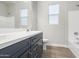 Stylish bathroom with wood-look tile, navy vanity with white countertop, and natural light at 5245 N 205Th Ln, Buckeye, AZ 85396