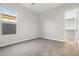 A carpeted bedroom is brightened by a large window, with a walk-in closet to the right at 5245 N 205Th Ln, Buckeye, AZ 85396