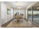 Bright dining room with a chandelier, table and chairs adjacent to sliding doors leading to outdoor patio at 5245 N 205Th Ln, Buckeye, AZ 85396