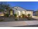 Inviting single-story home featuring an arched entryway, desert landscaping, and a warm exterior lighting at 5245 N 205Th Ln, Buckeye, AZ 85396