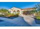 Single-story home featuring desert landscaping with flowering bushes, stucco exterior, arched entryway and attached garage at 5245 N 205Th Ln, Buckeye, AZ 85396