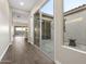 Hallway featuring wood-look tile with courtyard view through sliding glass doors at 5245 N 205Th Ln, Buckeye, AZ 85396