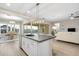 Open concept kitchen with white cabinets and a large center island and views to the dining room and living room at 5245 N 205Th Ln, Buckeye, AZ 85396