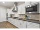 Elegant kitchen featuring white marble backsplash, dark countertops, stainless appliances, and plenty of counter space at 5245 N 205Th Ln, Buckeye, AZ 85396