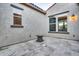 Travertine tile patio, stucco walls, outdoor lighting, and multiple sliding glass doors for easy indoor/outdoor living at 5245 N 205Th Ln, Buckeye, AZ 85396