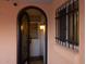 Home entryway featuring a decorative iron security door, wall-mounted lighting, and secure window covering at 5301 W Vernon Ave, Phoenix, AZ 85035