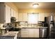 Well-lit kitchen with white cabinetry, stainless steel appliances, tile backsplash, and granite countertops at 5301 W Vernon Ave, Phoenix, AZ 85035