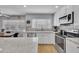 Well-lit kitchen featuring stainless steel appliances, tile backsplash, and granite countertops for the home chef at 5611 W Blackhawk Dr, Glendale, AZ 85308