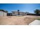 Backyard with a large dirt area, privacy fence, patio, and lawn waste container at 5638 N 61St Ln, Glendale, AZ 85301