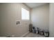 A well-lit laundry room with a window, flooring, and available plumbing connections at 5638 N 61St Ln, Glendale, AZ 85301