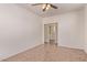 Empty bedroom features tile flooring, ceiling fan, with a doorway view to laundry room at 6755 S Tucana Ln, Gilbert, AZ 85298