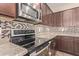 Close up of the stove and microwave with stylish backsplash and granite countertops at 6755 S Tucana Ln, Gilbert, AZ 85298