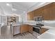 Modern kitchen showcases stainless steel appliances and wood cabinets with a view to the dining area at 705 W Queen Creek Rd # 1154, Chandler, AZ 85248