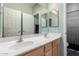 Bathroom with a double vanity sink, neutral walls, a large mirror, and a shower with a curtain at 7274 W Alta Vista Rd, Laveen, AZ 85339