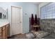 Bathroom featuring walk-in shower with tile surround, glass block window, wooden bench, and neutral color palette at 7274 W Alta Vista Rd, Laveen, AZ 85339