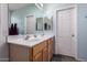 Bright bathroom with a double sink vanity, framed mirror and neutral flooring at 7274 W Alta Vista Rd, Laveen, AZ 85339