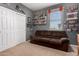 Bedroom featuring a brown couch and sports memorabilia displayed on the shelves and walls at 7274 W Alta Vista Rd, Laveen, AZ 85339