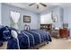 Cozy bedroom with blue walls, ceiling fan, dresser, and ample natural light from the window at 7274 W Alta Vista Rd, Laveen, AZ 85339