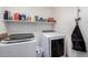 Modern laundry room with front loading washer and dryer and ample shelving space for storage at 7274 W Alta Vista Rd, Laveen, AZ 85339