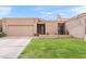 Charming single-story home featuring a manicured lawn, private drive, and desert landscaping at 7937 E Solano Dr, Scottsdale, AZ 85250