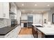 Modern kitchen with white cabinets, stainless appliances, and a large central island at 7937 E Solano Dr, Scottsdale, AZ 85250