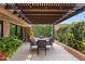 Inviting outdoor patio with charming pergola, dining set, and lush greenery offering a serene space at 7937 E Solano Dr, Scottsdale, AZ 85250