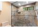 Tiled walk-in shower featuring glass doors, a shower head, and tiled floors at 7937 E Solano Dr, Scottsdale, AZ 85250