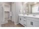 Elegant bathroom boasts double sinks with white cabinets, creating a bright and functional space at 8025 W Gardenia Ave, Glendale, AZ 85303