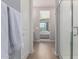 Bathroom showcasing a modern shower, white cabinets, and a glimpse into a well-lit bedroom at 8025 W Gardenia Ave, Glendale, AZ 85303