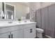 Bright bathroom with double vanity sinks, white cabinets, and modern fixtures at 8025 W Gardenia Ave, Glendale, AZ 85303