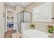 Well-lit bathroom featuring a walk-in shower, soaking tub, and an open closet area at 8857 S 167Th Ln, Goodyear, AZ 85338