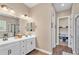 Bright bathroom featuring double sinks, vanity and walk-in shower with glass door at 8857 S 167Th Ln, Goodyear, AZ 85338