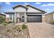 Charming single-story home with well-kept desert landscaping and a brick-paved driveway at 8857 S 167Th Ln, Goodyear, AZ 85338