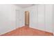 Clean bedroom with red geometric patterned floor and simple sliding door closet at 10792 W Elm Ln, Avondale, AZ 85323