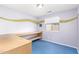 Bedroom with bright lavender walls, built-in desk, and blue flooring at 10792 W Elm Ln, Avondale, AZ 85323