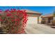 Welcoming single-story house with a two-car garage and vibrant bougainvillea at 10792 W Elm Ln, Avondale, AZ 85323