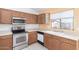 Functional kitchen featuring oak cabinets, white appliances, and plenty of counter space at 10792 W Elm Ln, Avondale, AZ 85323