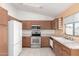 Efficient kitchen featuring white appliances and oak cabinets at 10792 W Elm Ln, Avondale, AZ 85323