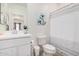 Clean bathroom with a white vanity, toilet, and a shower with a striped curtain at 12125 W Levi Dr, Avondale, AZ 85323