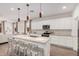 Modern kitchen with white cabinets, a center island with barstool seating, and views of the living space at 12125 W Levi Dr, Avondale, AZ 85323